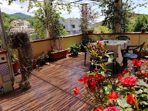 A wooden deck with potted plants and a table with chairs. - B&B Moscani (Salerno)