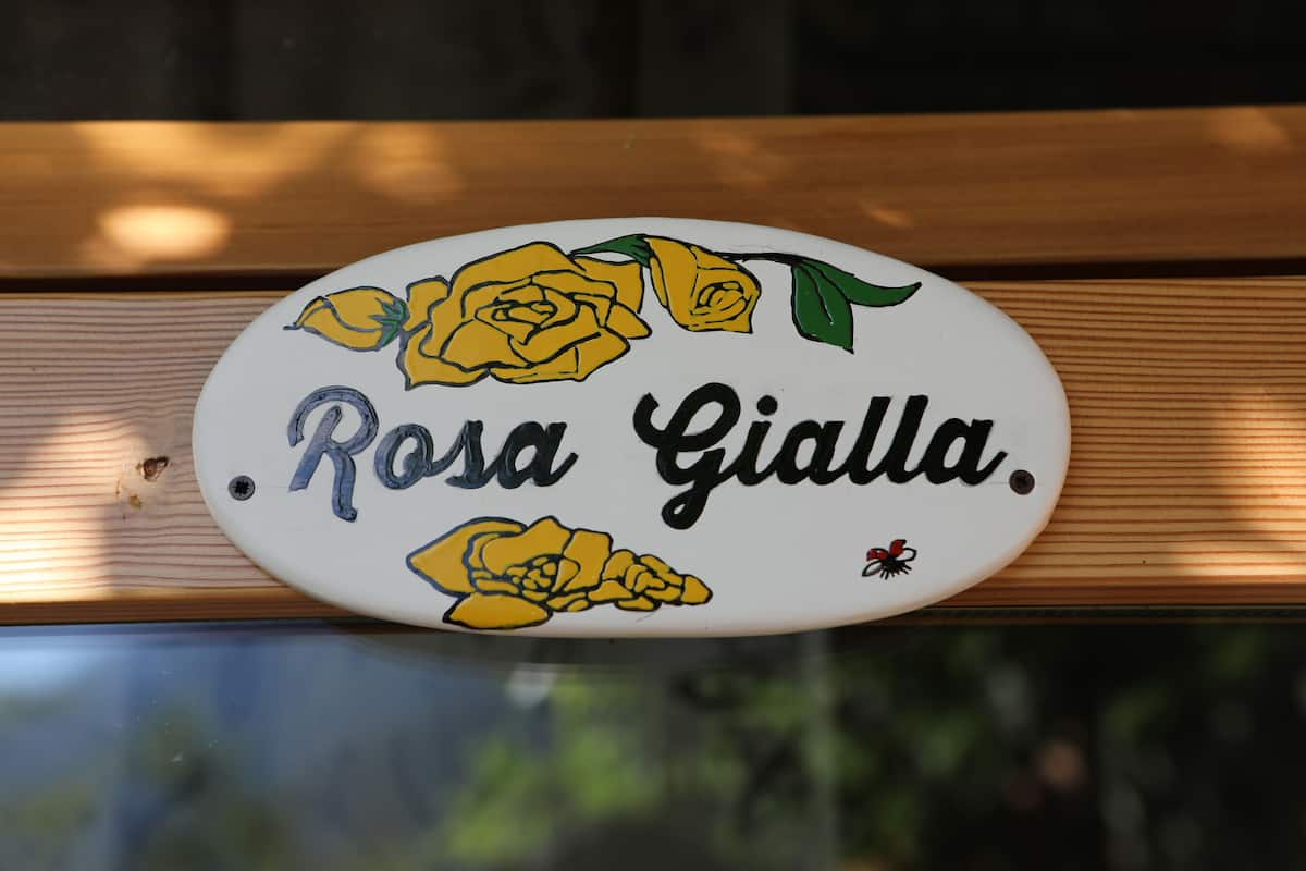 Une enseigne portant le nom « Rosa Gialla » et ornée de roses jaunes.
