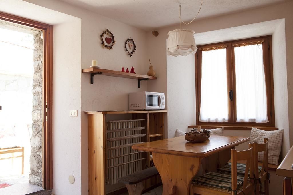 A cozy kitchen with a wooden table, a microwave, and a hanging light fixture.