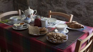 A breakfast table set with bread, pastries, and tea. - Le Rosier B&B e Appartamento (Saint-Vincent)