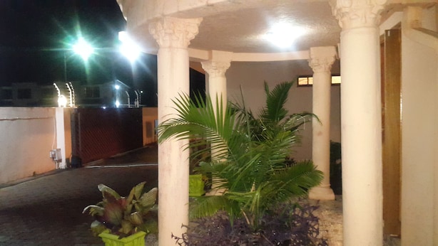 A covered outdoor area with columns, potted plants, and a gated entrance. - Tintech Bed & Breakfast (Francistown)