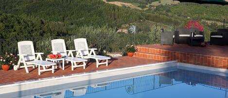 Seasonal outdoor pool, open 8 AM to 8 PM, pool umbrellas, pool loungers