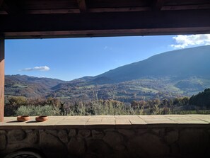 Eine Steinsichtmauer mit Blick auf eine gebirgige Landschaft.