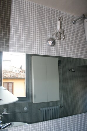 Bathroom features a sink, mirror, towel rack, radiator, and toilet paper holder.
