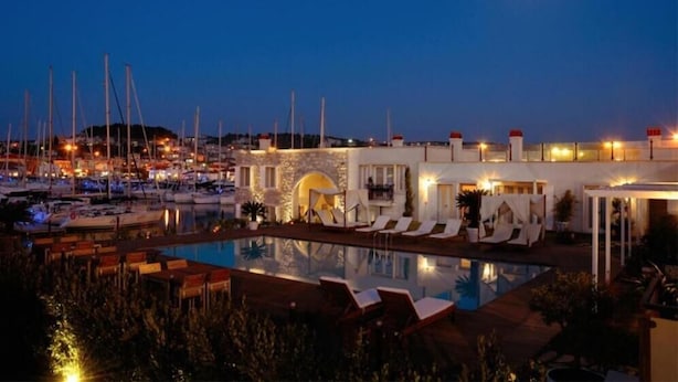 Uma marina com barcos, uma piscina e um edifício com área de estar ao ar livre.