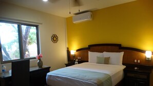 A hotel room with a bed, bedside tables, a desk, and a chair. - Casa San Juan (Mérida)