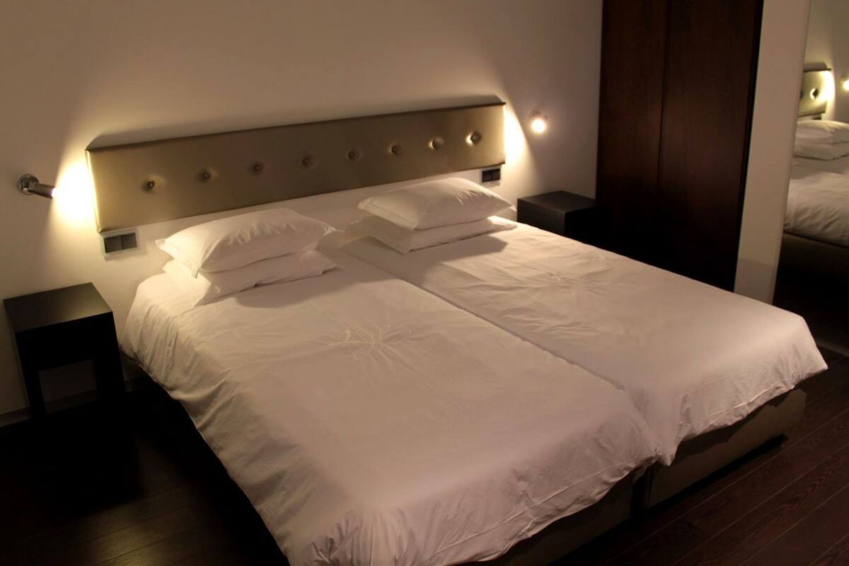 A double bed with a headboard, two bedside tables, and a nightstand.