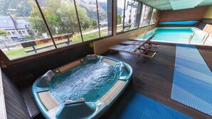 Un jacuzzi con vistas a una montaña y una zona de piscina.