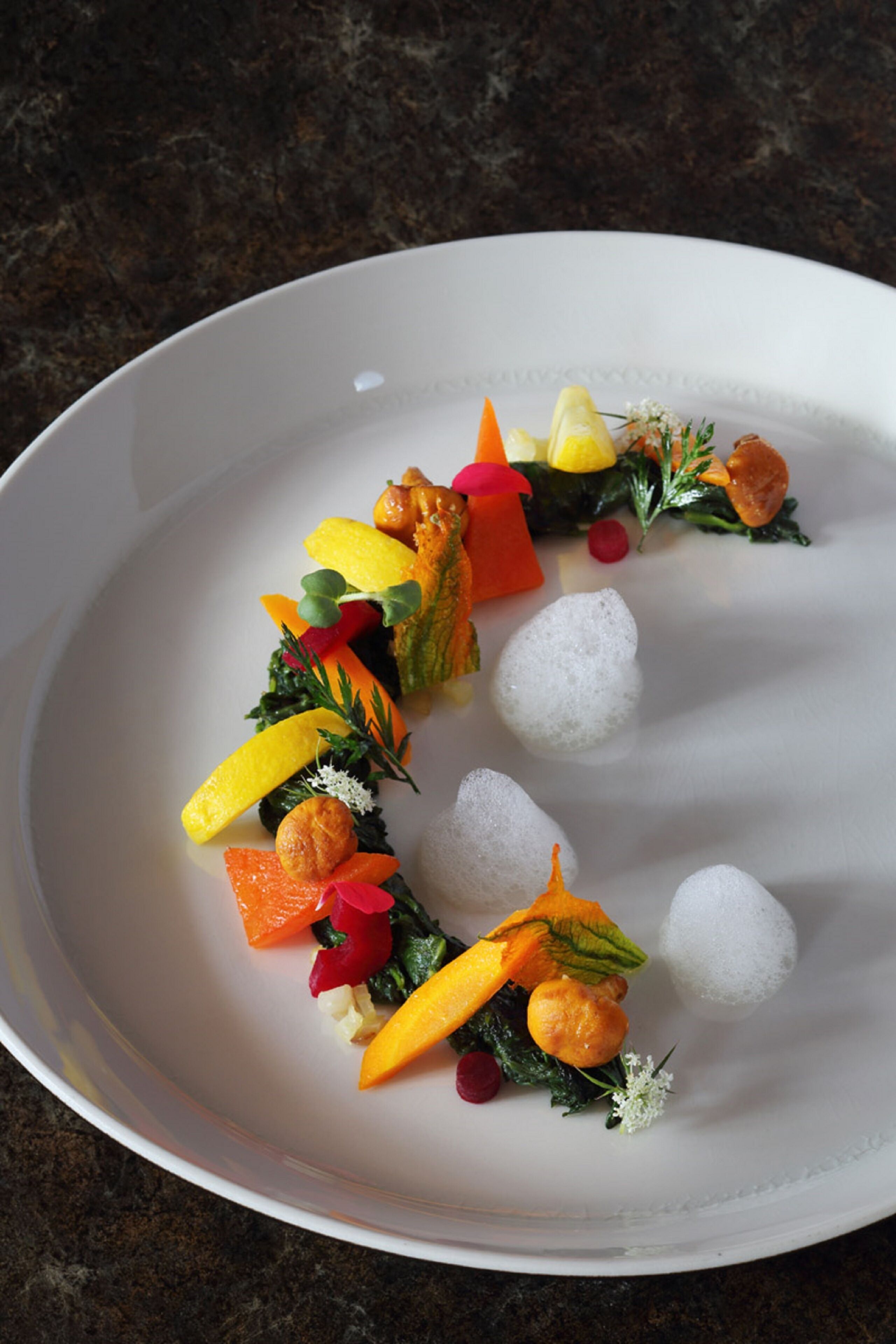 A white plate with a variety of colorful vegetables and garnishes.