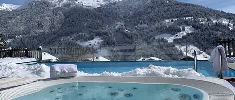 Una piscina al aire libre, sillones reclinables de piscina