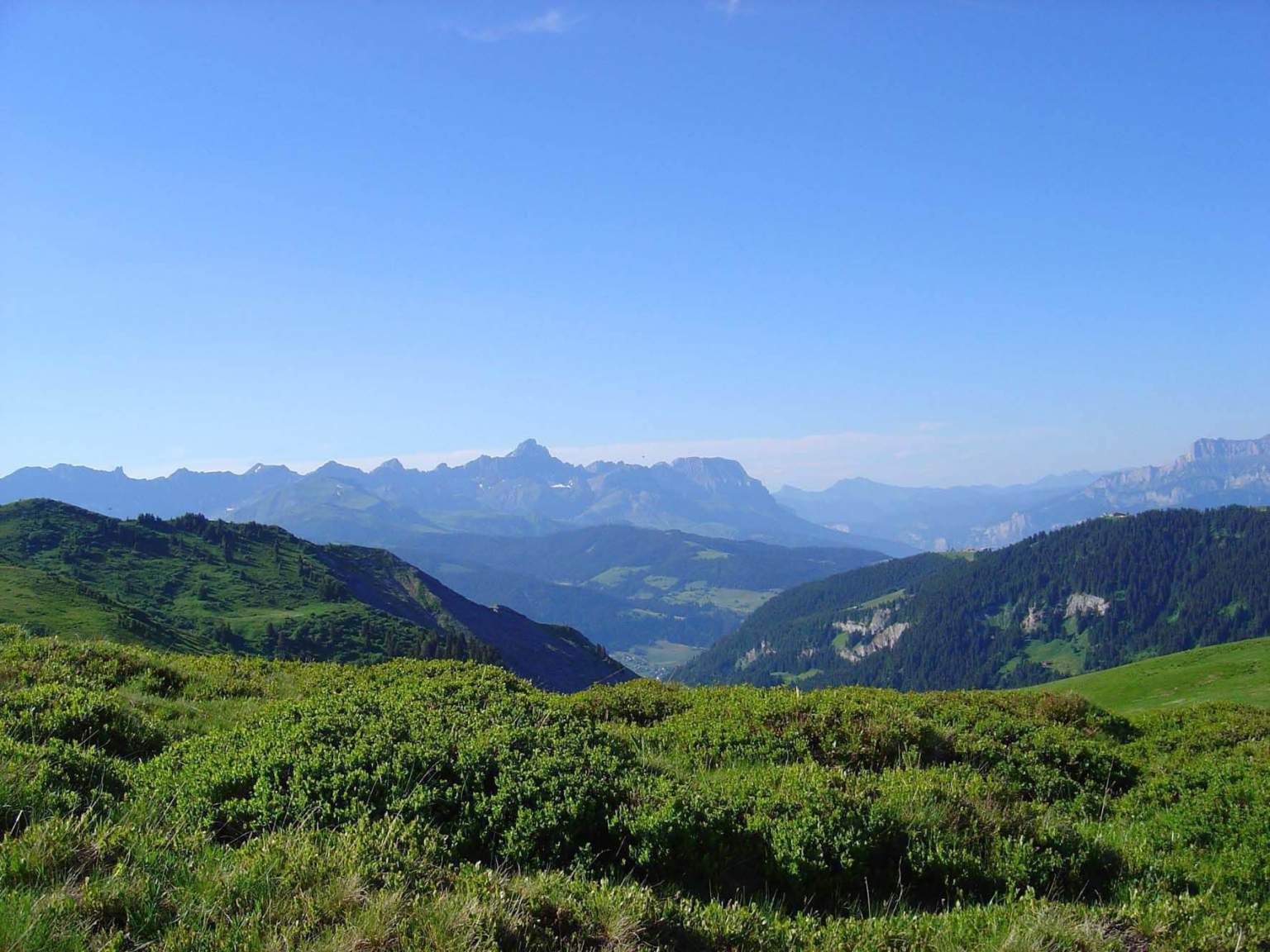 Un paysage montagneux, avec des collines verdoyantes et une vallée.