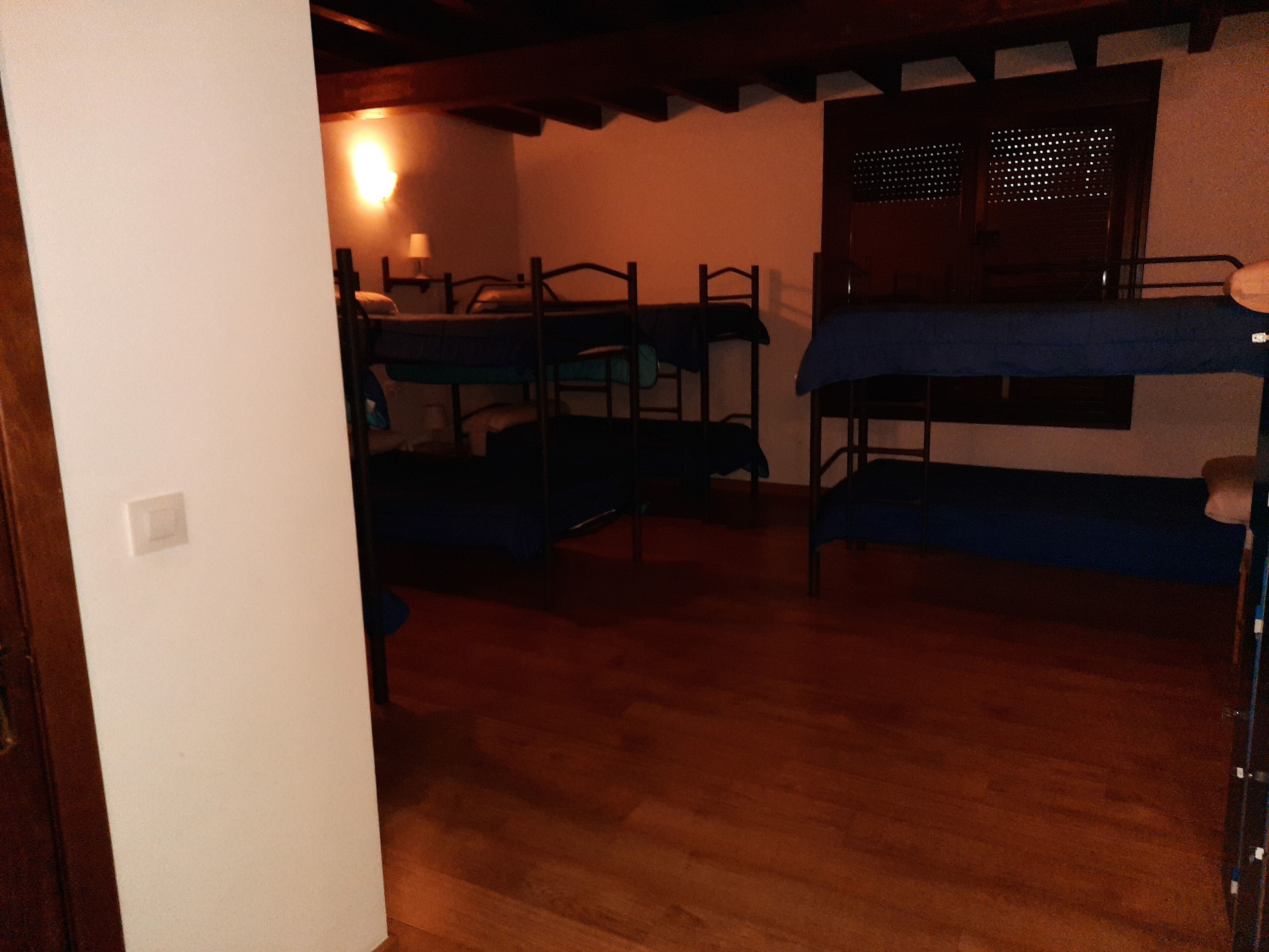 Un dormitorio con literas, un escritorio y una ventana con persianas.