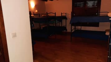 Un dormitorio con literas, un escritorio y una ventana con persianas.