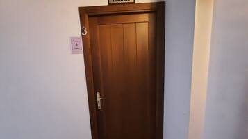 Un pasillo con una puerta de madera que lleva el nombre 'ANDRES'.
