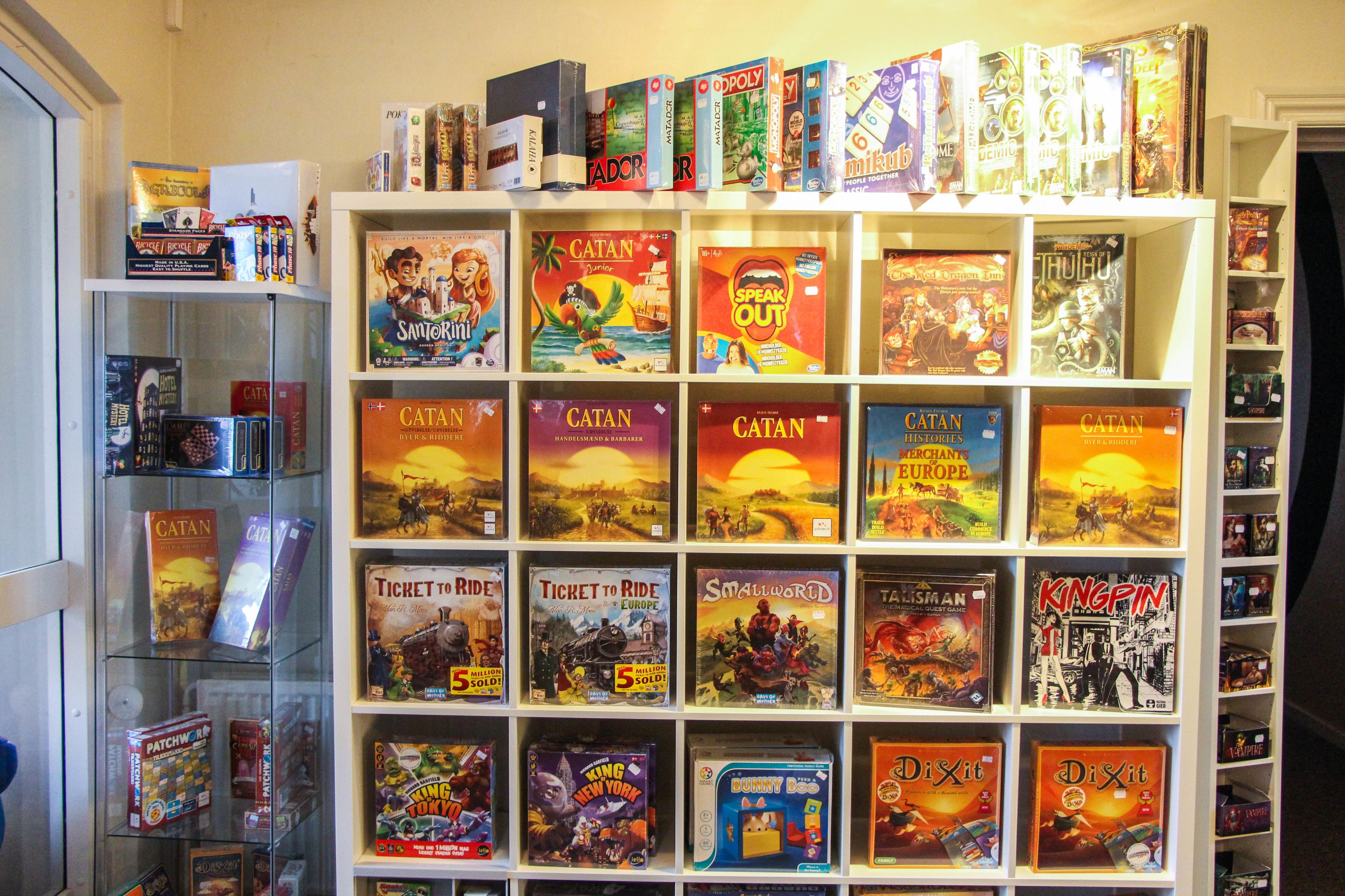 Una estantería con varios juegos de mesa y juegos en caja.