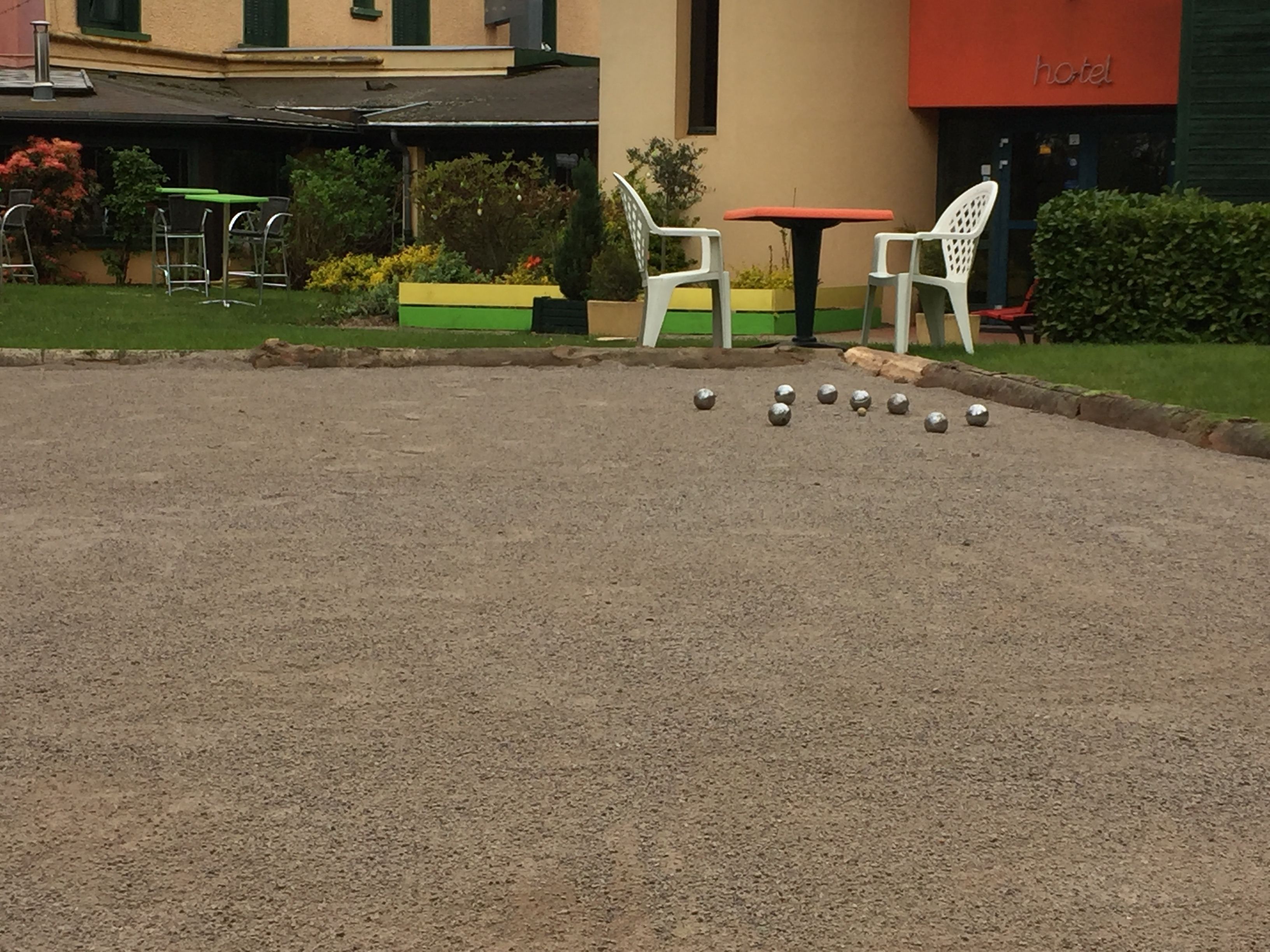 Un patio con un juego de croquet, una mesa y sillas.