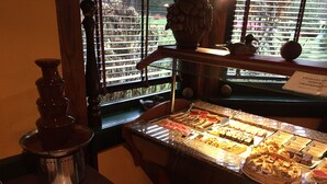 A dessert display with various sweets and a chocolate fountain. - Hôtel Le Pavillon (Cours)