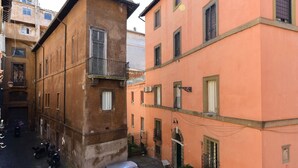 Une rue étroite, bordée de bâtiments des deux côtés, avec des balcons et des fenêtres.