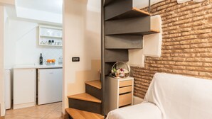 Um espaço compacto com cozinha, escada e cama.