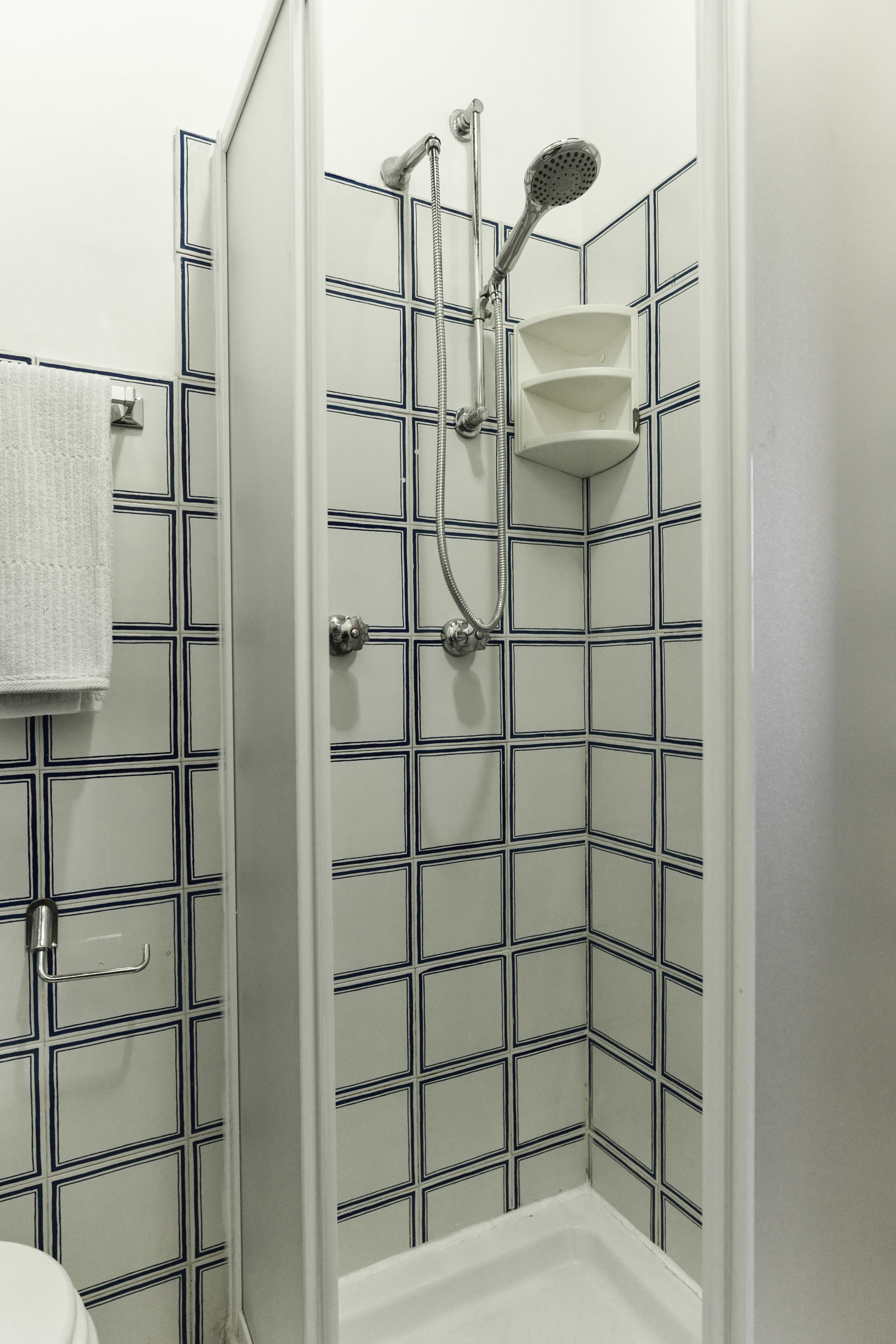 A bathroom with a shower, tiled walls, and a toilet.