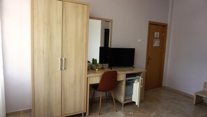 A room with a wooden wardrobe, a desk with a computer, a chair, and a small table. - OITUZ Boutique Residence (Mangalia)