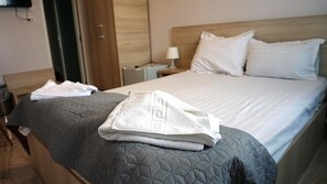 A hotel room with a bed, a nightstand with a lamp, and a wooden wardrobe. - OITUZ Boutique Residence (Mangalia)