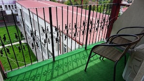 A balcony with a green artificial turf floor, a metal railing with decorative elements, and a wicker chair. - OITUZ Boutique Residence (Mangalia)