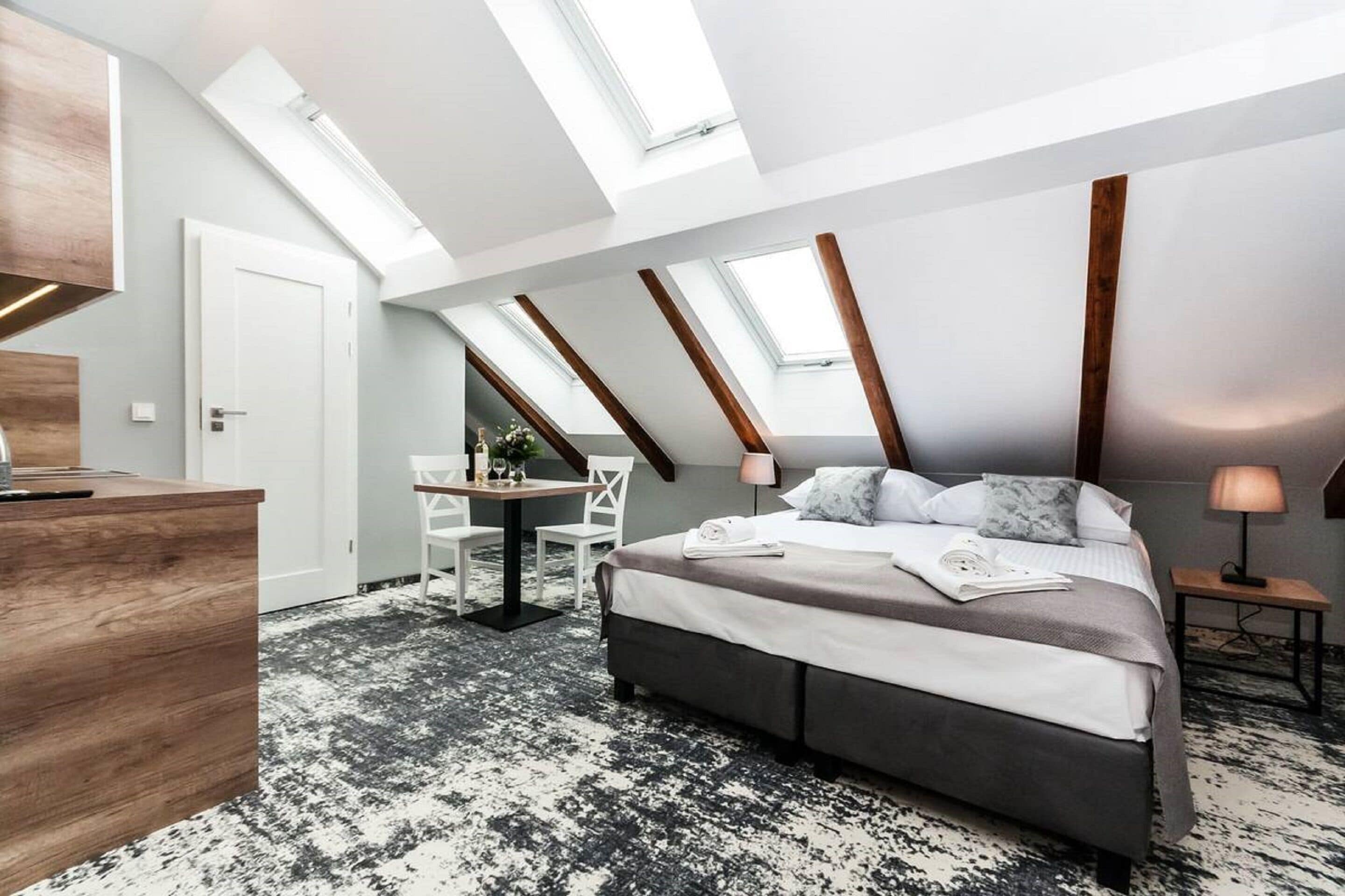 A modern bedroom with a skylight, a desk, and a chair.