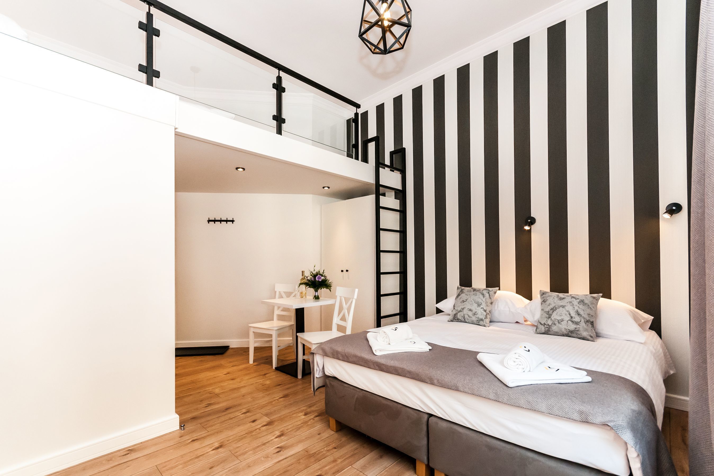 Ein modernes Schlafzimmer mit Stockbett, kleinem Schreibtisch und Treppe.