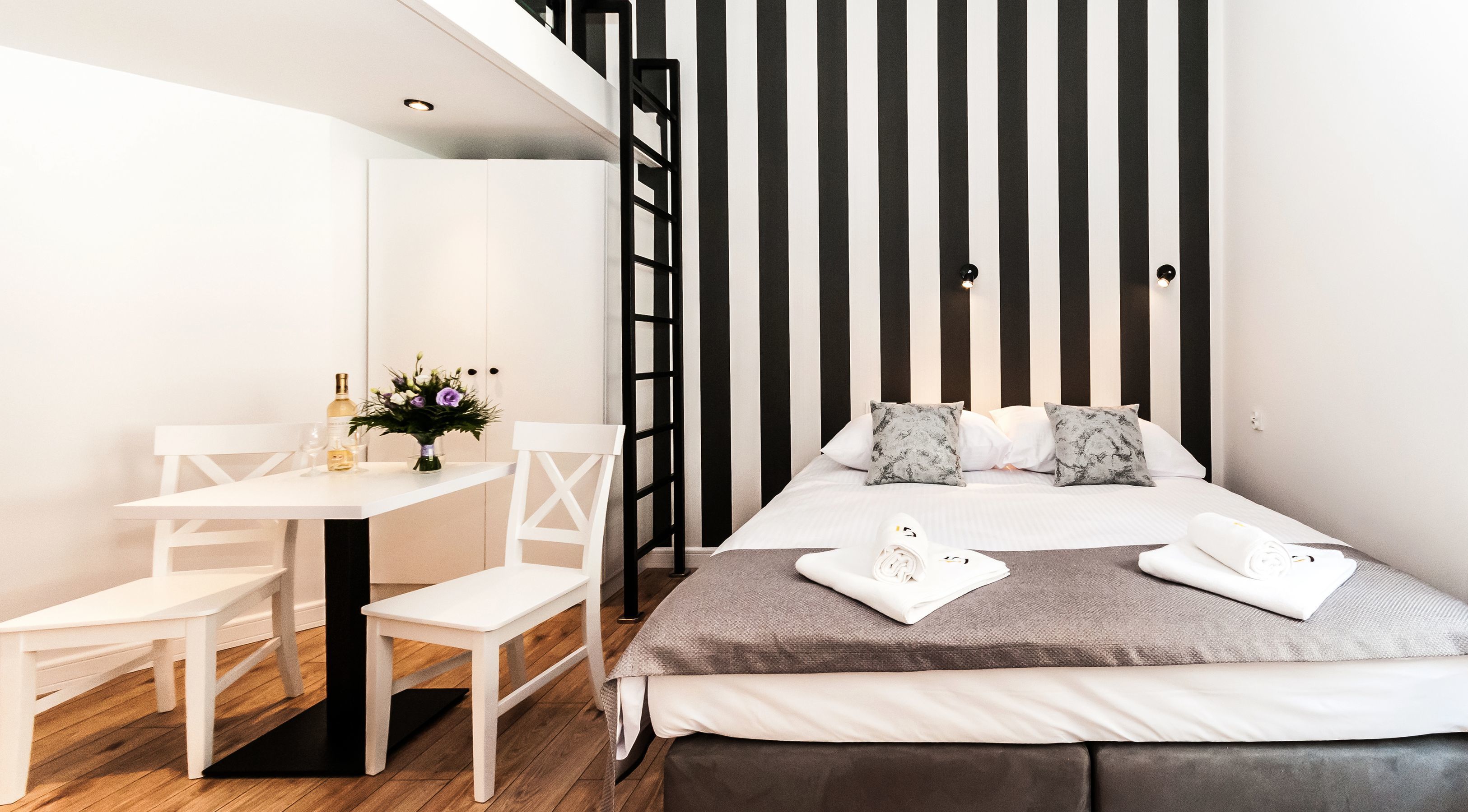 A modern bedroom with a bed, a desk, and a chair.