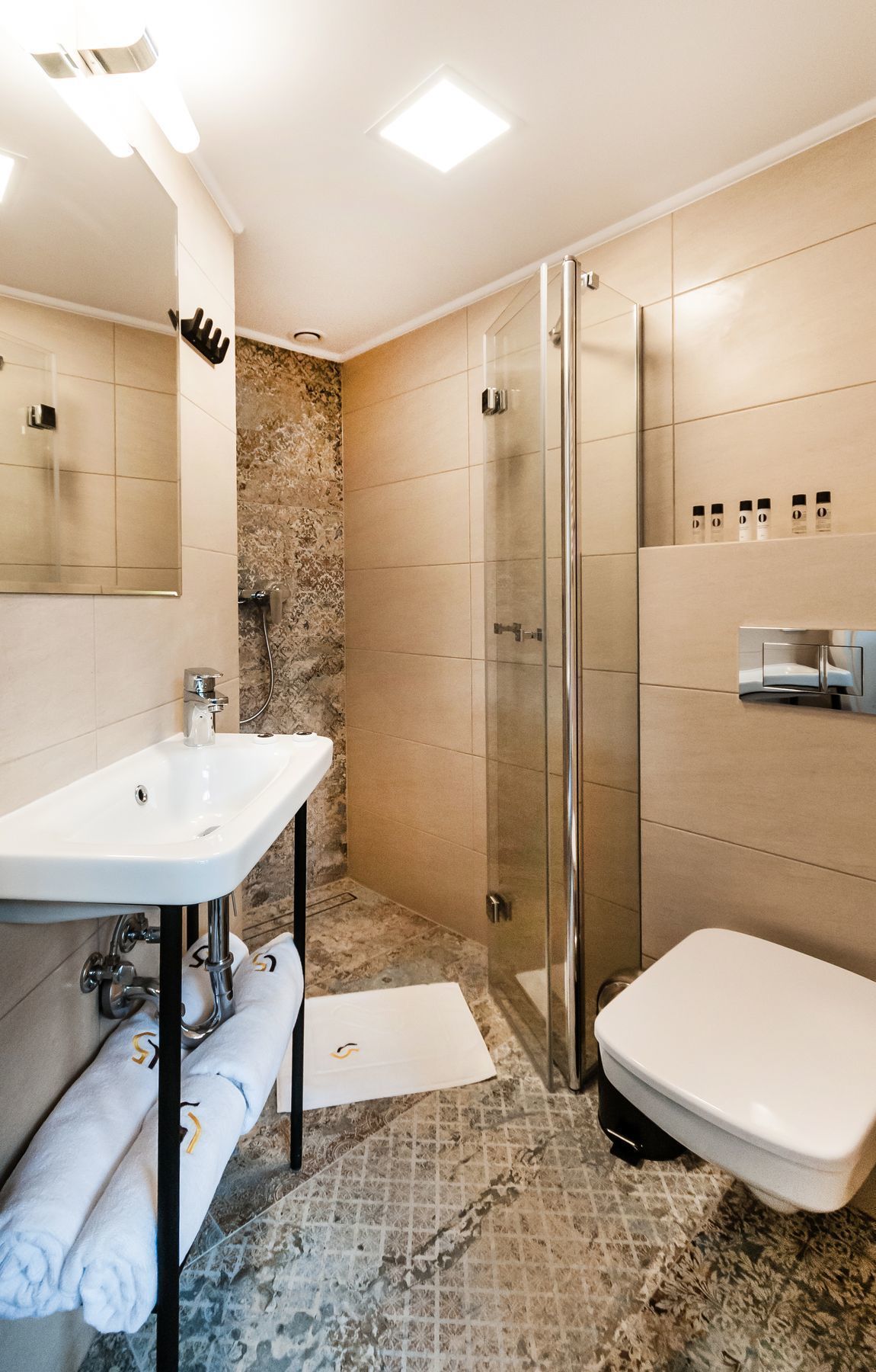 Ein modernes Badezimmer mit Duschkabine aus Glas, einem weißen Waschbecken und einer Toilette.