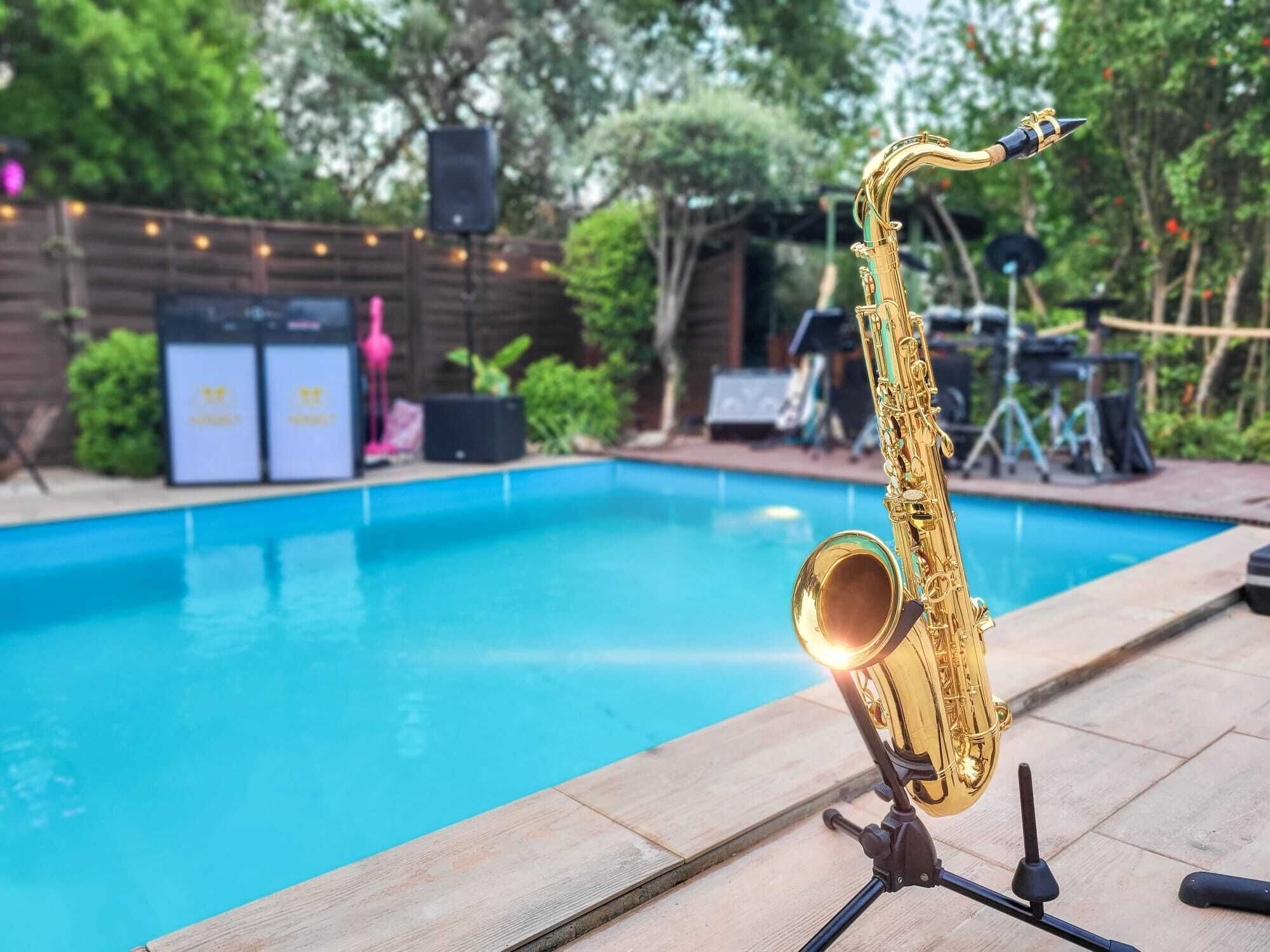 Un saxofón sobre un atril junto a una piscina.