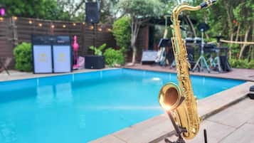 Un saxofón sobre un atril junto a una piscina.