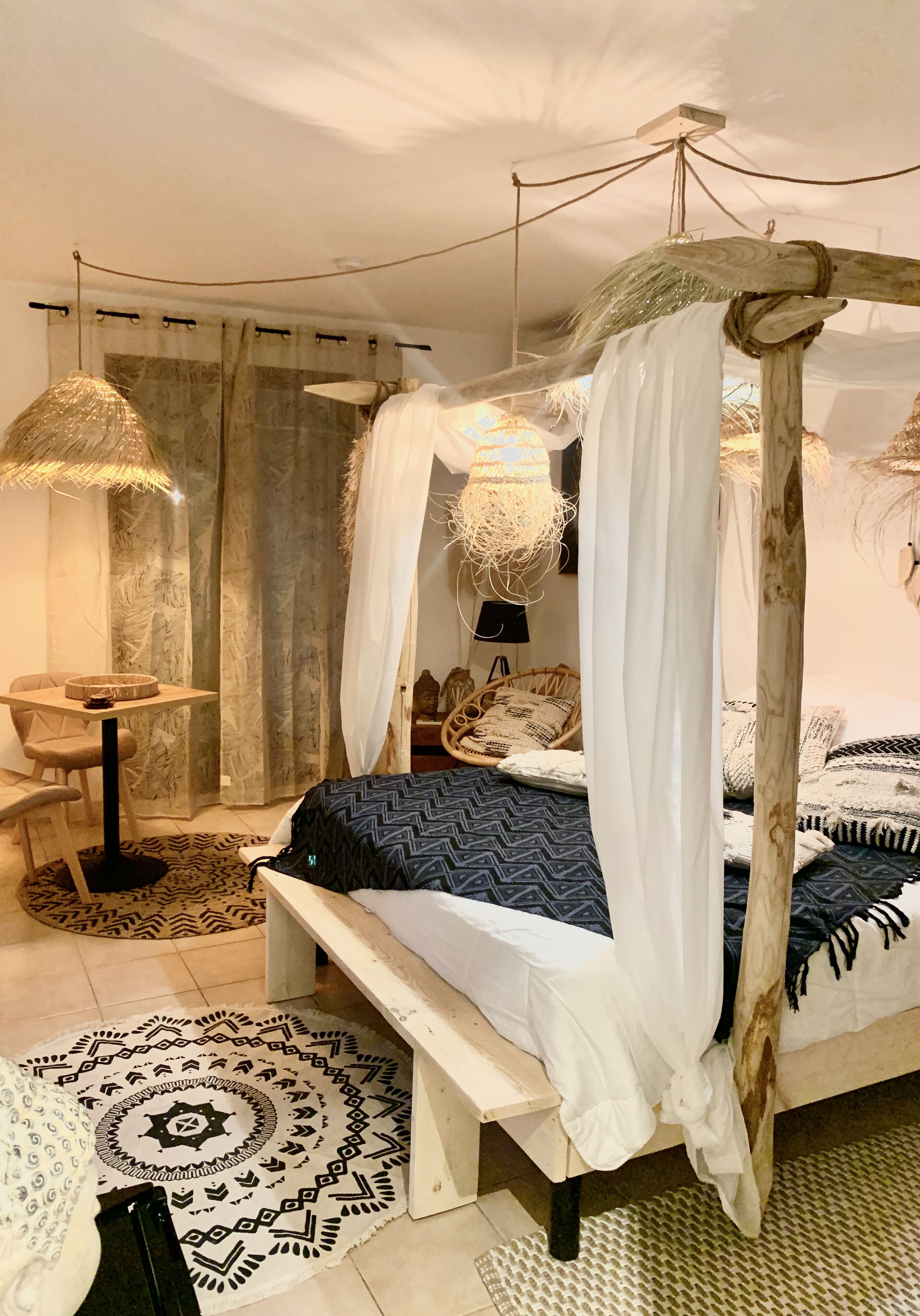 Ein Schlafzimmer mit Himmelbett, einem runden Tisch und einem Stuhl.