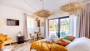 Ein Hotelzimmer mit Bett, Schreibtisch, Fernseher und Blick nach draußen.