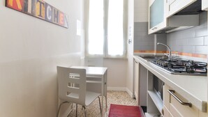 A small kitchen with a white countertop, a gas stove, and a window. - Pantheon Cozy Apartment n. 4 (Rome)