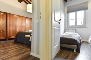 A bedroom with a bed, wooden wardrobe, and a window with blinds. - Pantheon View from Terrace Apartment (Rome)