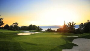 A golf course with a water hazard, sand bunkers, and a flagstick. - Savoy Hôtel Evian (Evian-les-Bains)