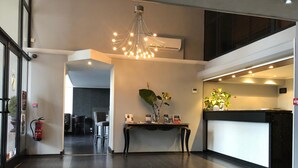 A modern hotel lobby with a reception desk, a chandelier, and a fire extinguisher. - Savoy Hôtel Evian (Evian-les-Bains)