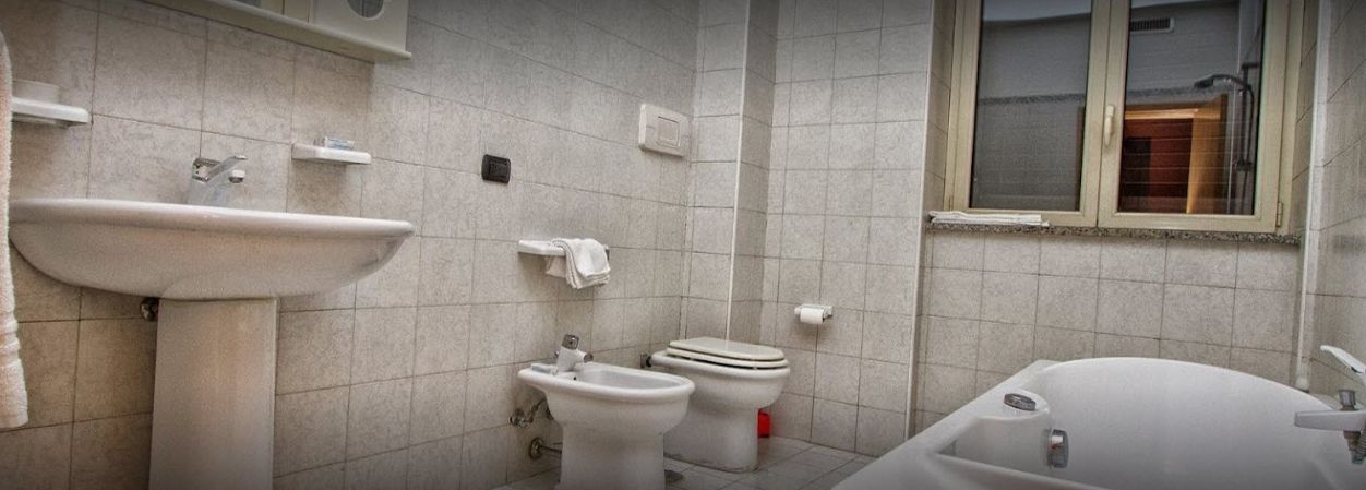 A bathroom with a sink, bidet, toilet, and bathtub.