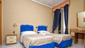 A room with two beds, a desk, a lamp, and a mirror. - Hotel Silverado (Orta di Atella)