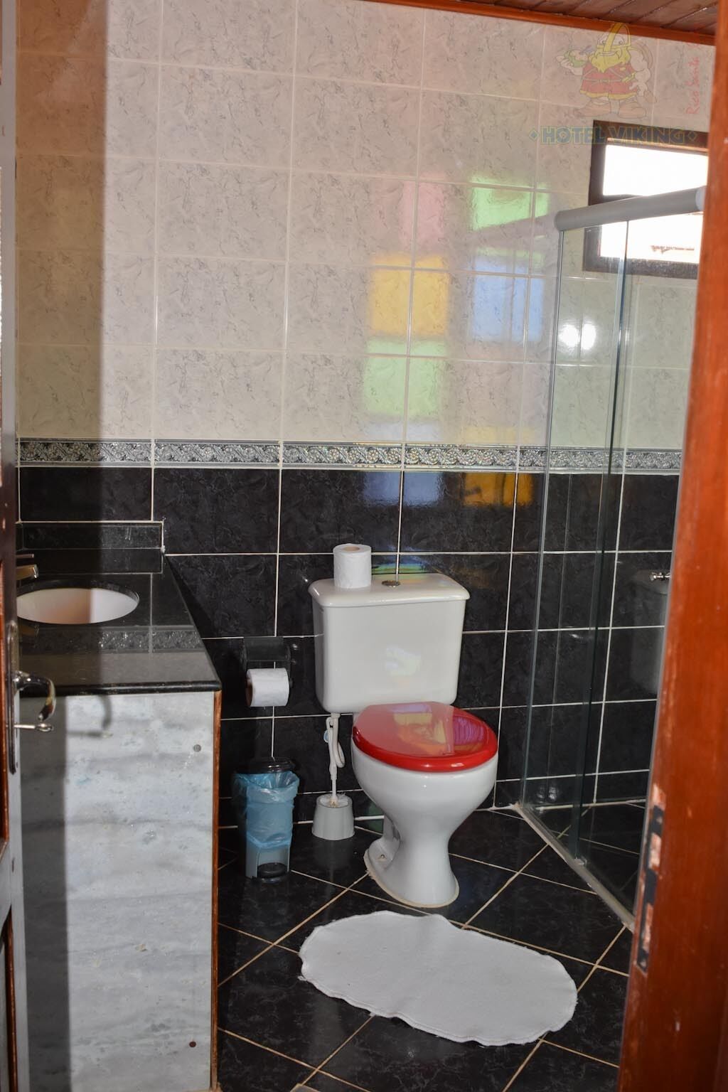 Une petite salle de bain avec des toilettes, un lavabo et un miroir.