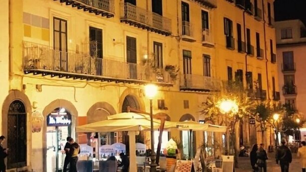 A historic building with multiple balconies and a ground-level café.