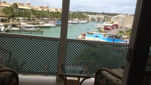 A balcony with a view of a marina and a pool. - Holiday Home at 163 Port St Charles (Speightstown)