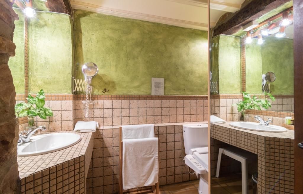 Een badkamer met twee wastafels, een spiegel en een handdoekhouder.