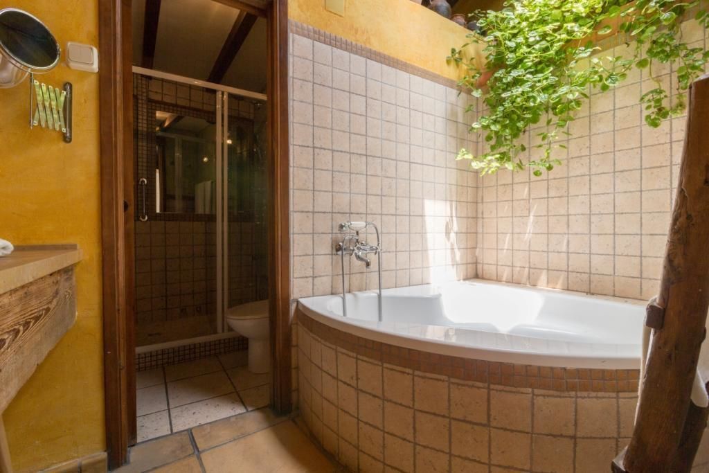 A bathroom with a bathtub, shower, and a wooden vanity.