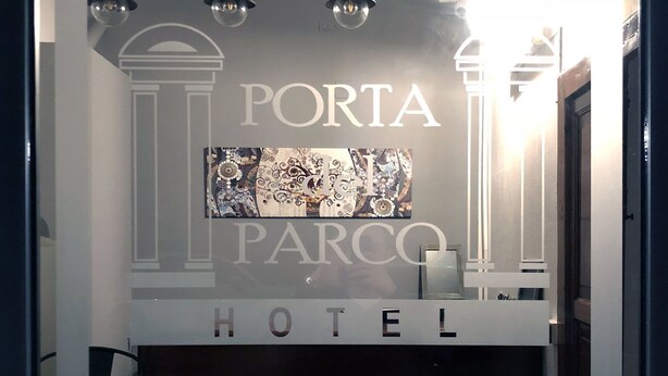 Een hotelentree met een bord waarop 'PORTA PARCO HOTEL' staat.