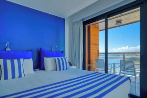 A hotel room with a large bed, a view of the sea, and a balcony with chairs. - Hotel Boutique La Marquesina Adults Only (La Oliva)