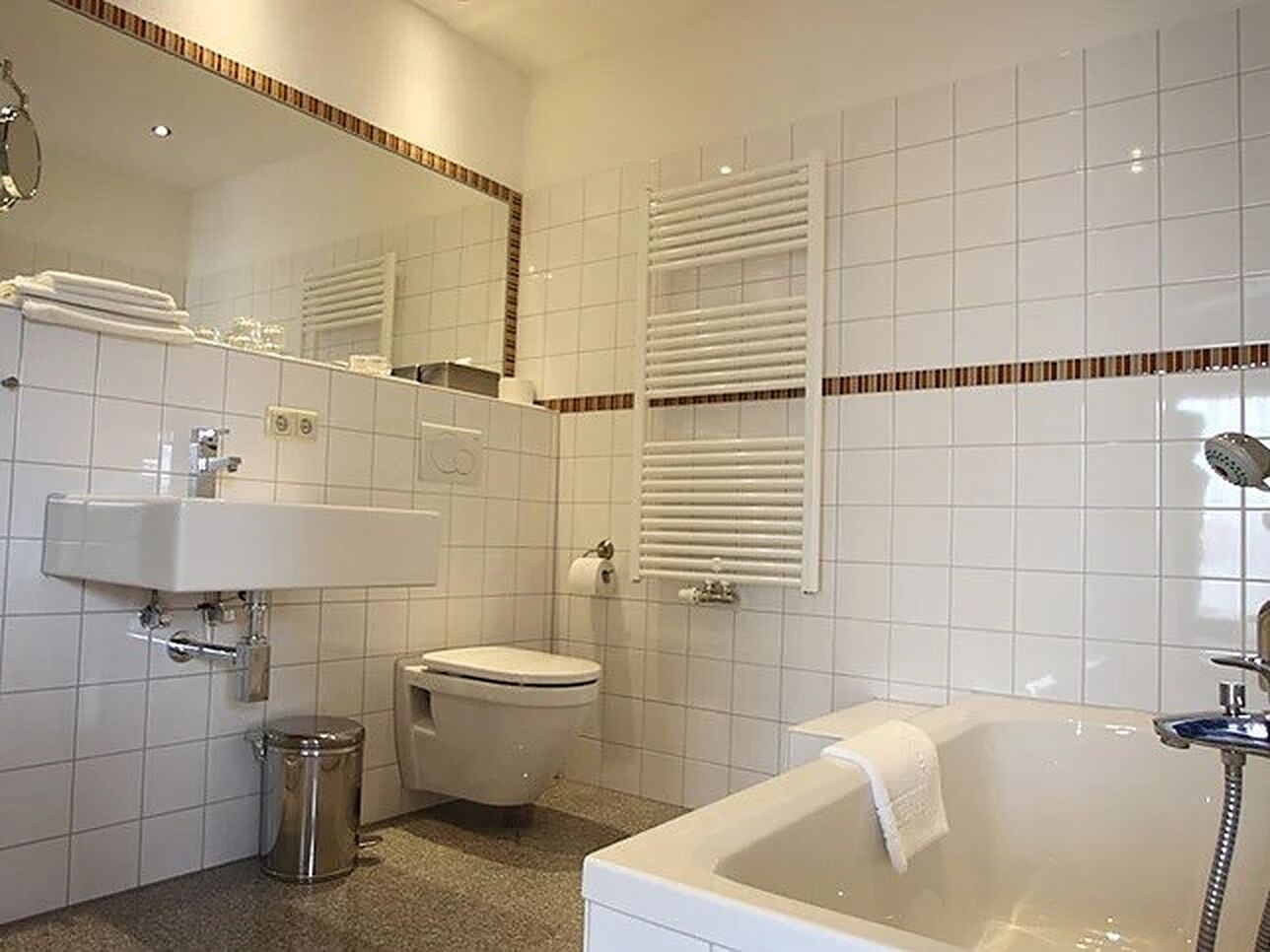 A modern bathroom with a sink, toilet, and bathtub.