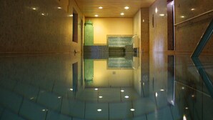A polished indoor corridor with a reflective floor, a green textured wall, and a wooden ceiling. - Kur- & Landhotel Borstel-Treff (Dabel)